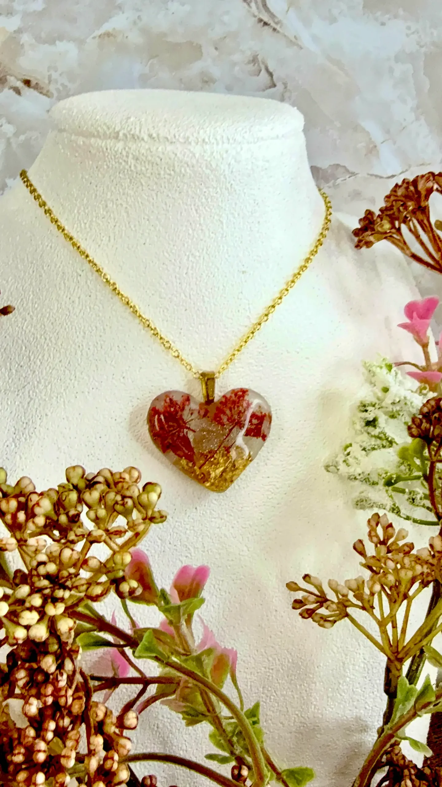 Heart Pendant -- Tiny bouquets of pink flowers set into gold flakes makes for the representation of two cherry trees set into a golden field. Shimmering flecks around the landscape make for a fantasy landscape, somewhere between winter and spring. Made of resin.