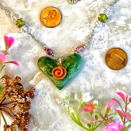Heart Pendant -- shimmering turquoise and a big coral flower, made with polymer clay. Alternating pink and green preciosa beads make for a whimsical, yet high end piece.