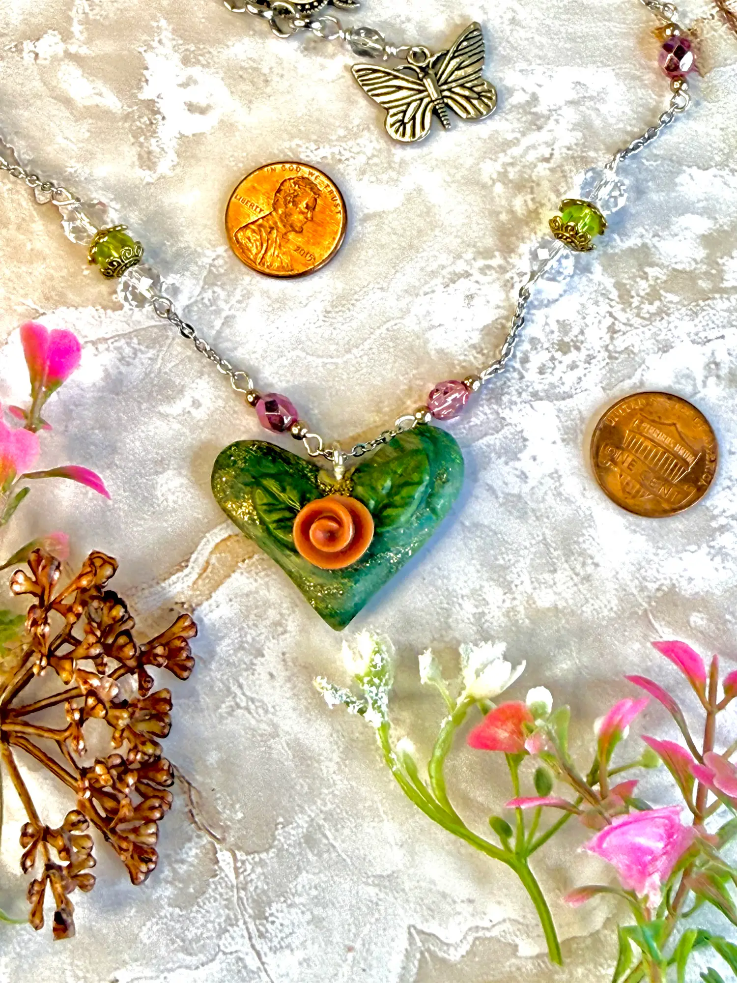 Heart Pendant -- shimmering turquoise and a big coral flower, made with polymer clay. Alternating pink and green preciosa beads make for a whimsical, yet high end piece.